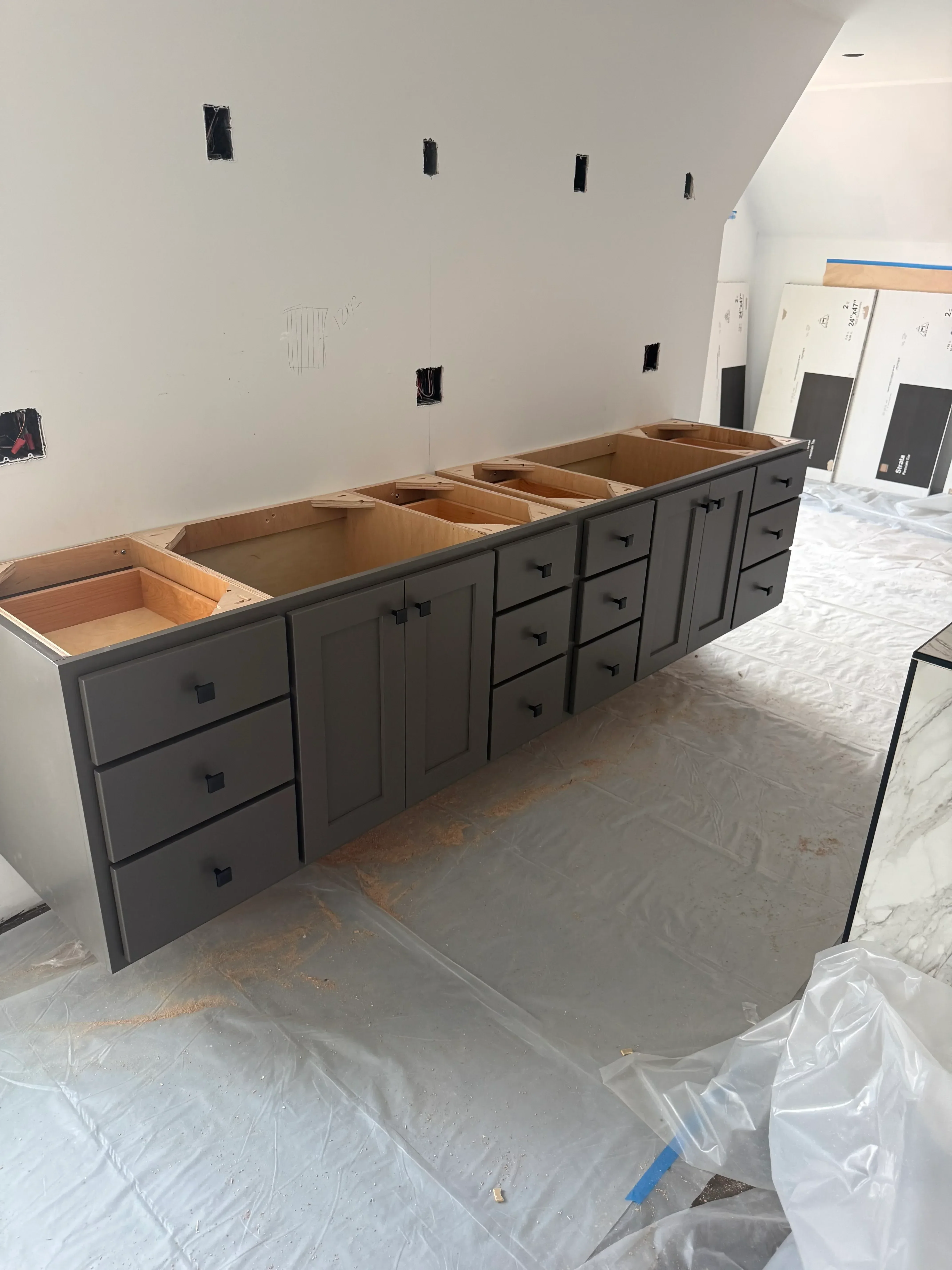 Drywall with electrical outlet boxes installed, plastic protection covering, interior construction phase