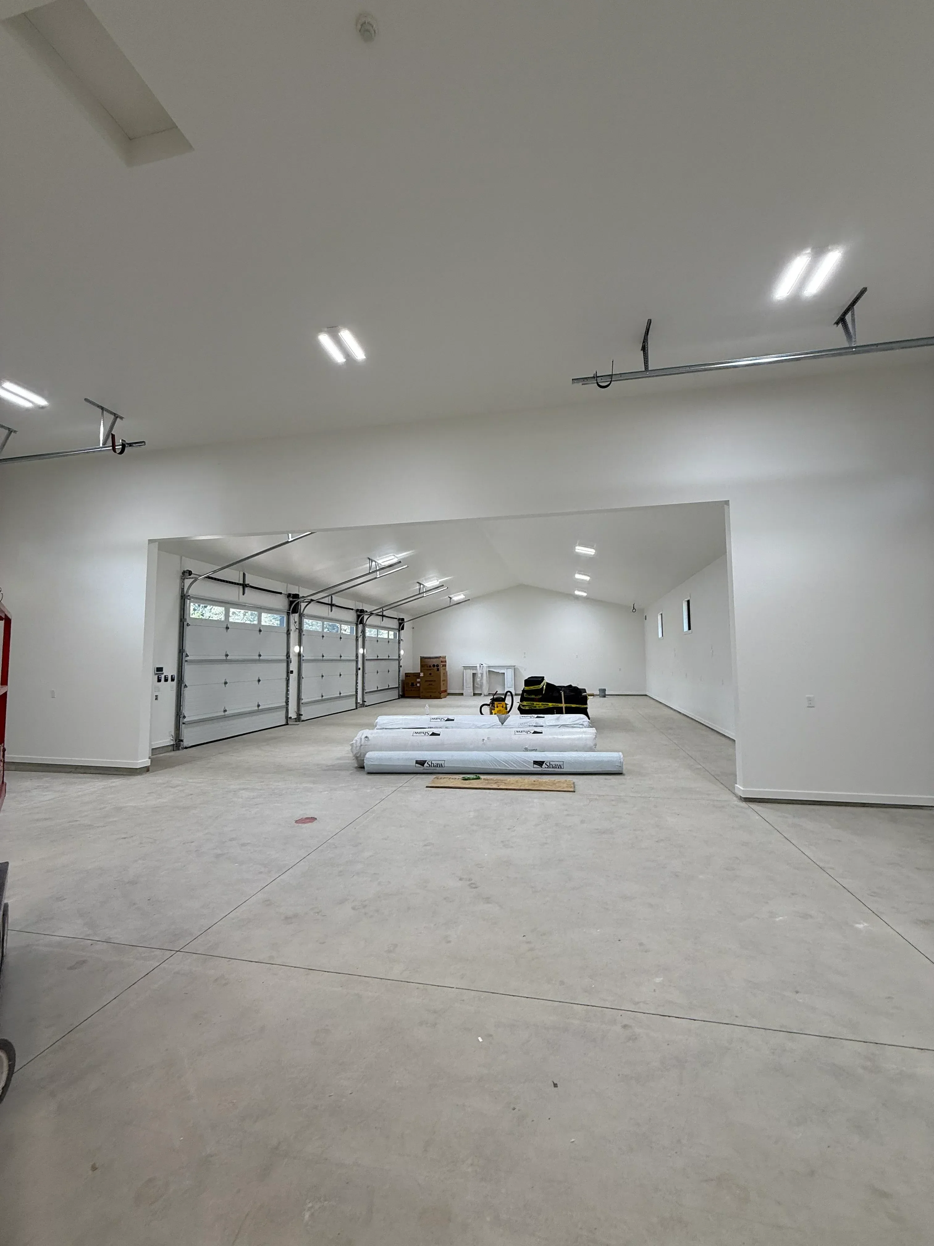 Commercial hallway with drywall walls, recessed ceiling lights, and electrical rough-in installation